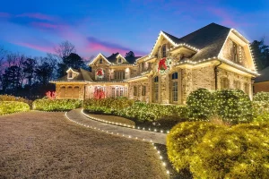 Illuminated luxury house with festive Christmas decorations at dusk.