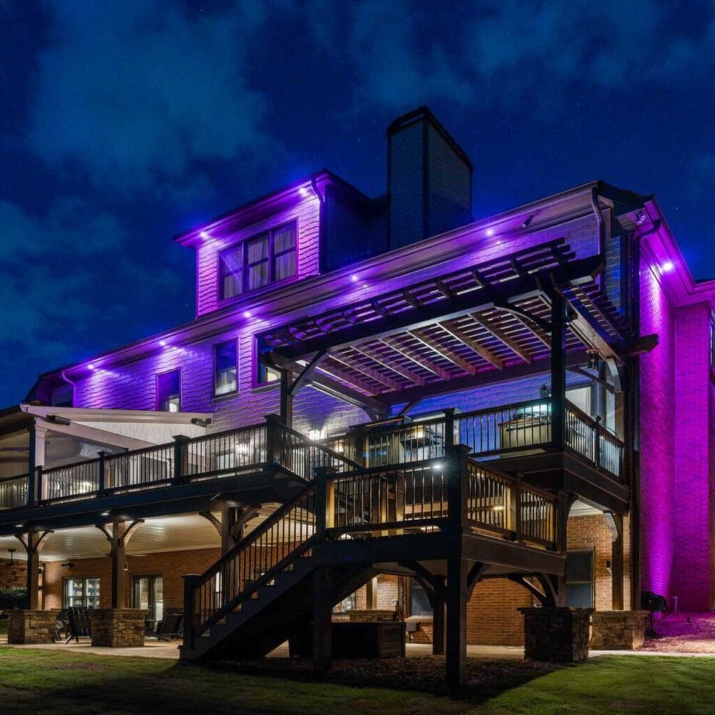 House with purple outdoor lighting at night.