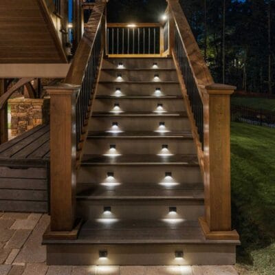 Illuminated outdoor wooden staircase at night.
