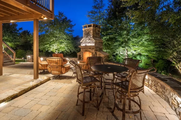 Outdoor patio with fireplace and seating at dusk.