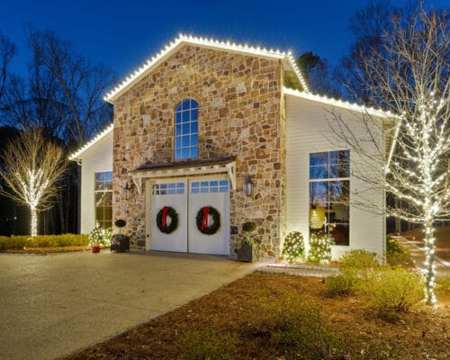 Stone house with Christmas lights at night.