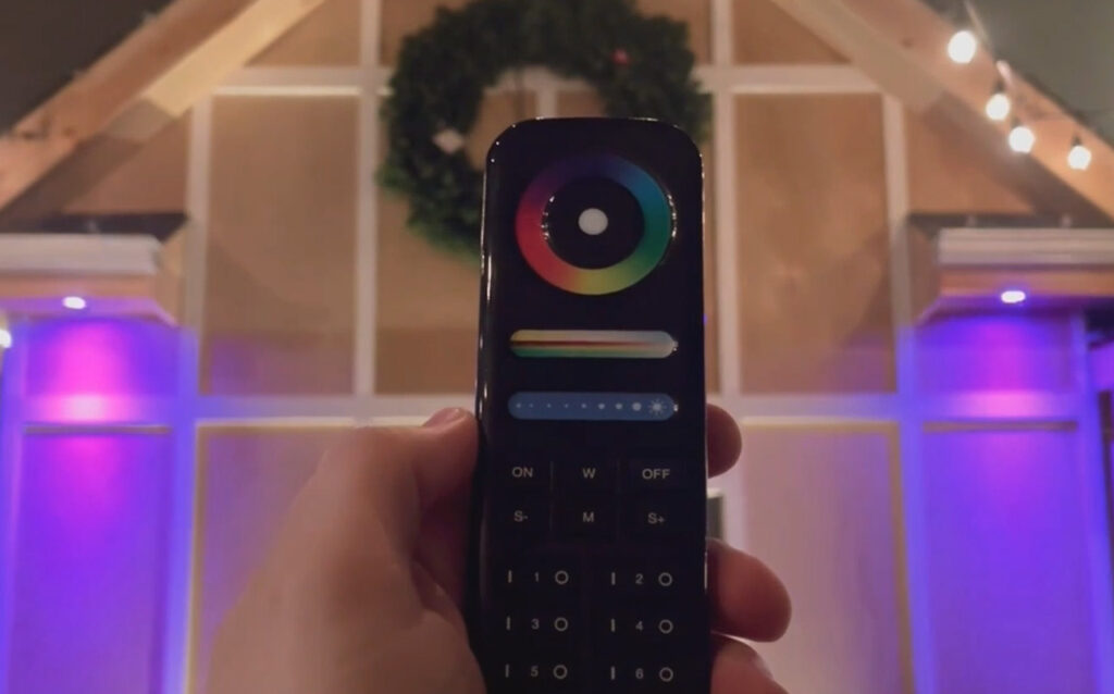 Remote control changes lighting in decorated room.