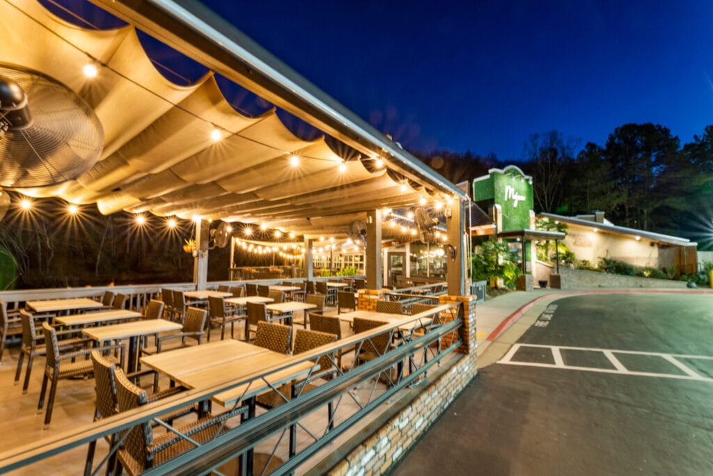 Outdoor restaurant patio with string lights at night.