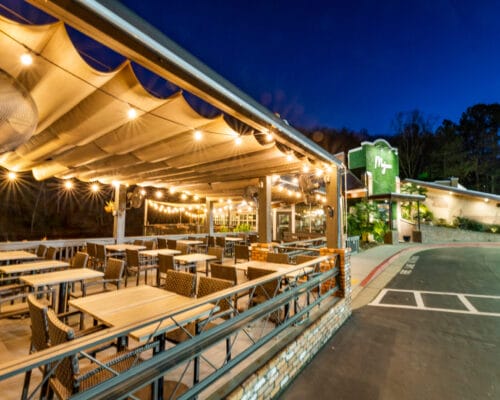 Outdoor restaurant patio with string lights at night.