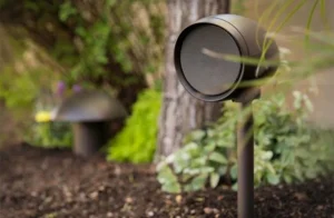 Outdoor garden speaker mounted on stake among plants